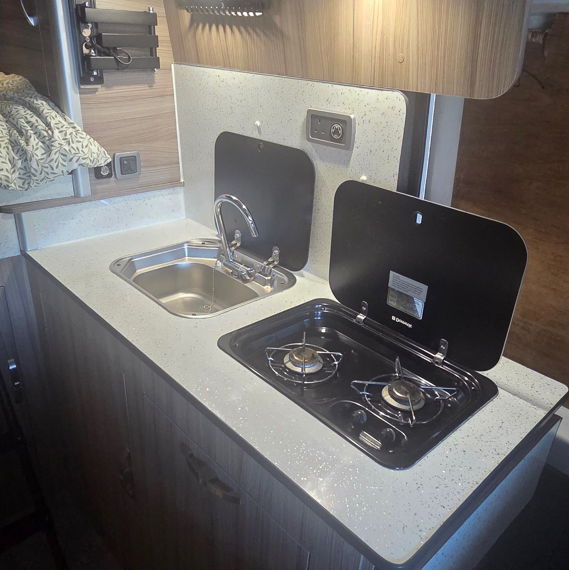 Kitchen finished: sink, twin-burner hob and speckled worktop.
